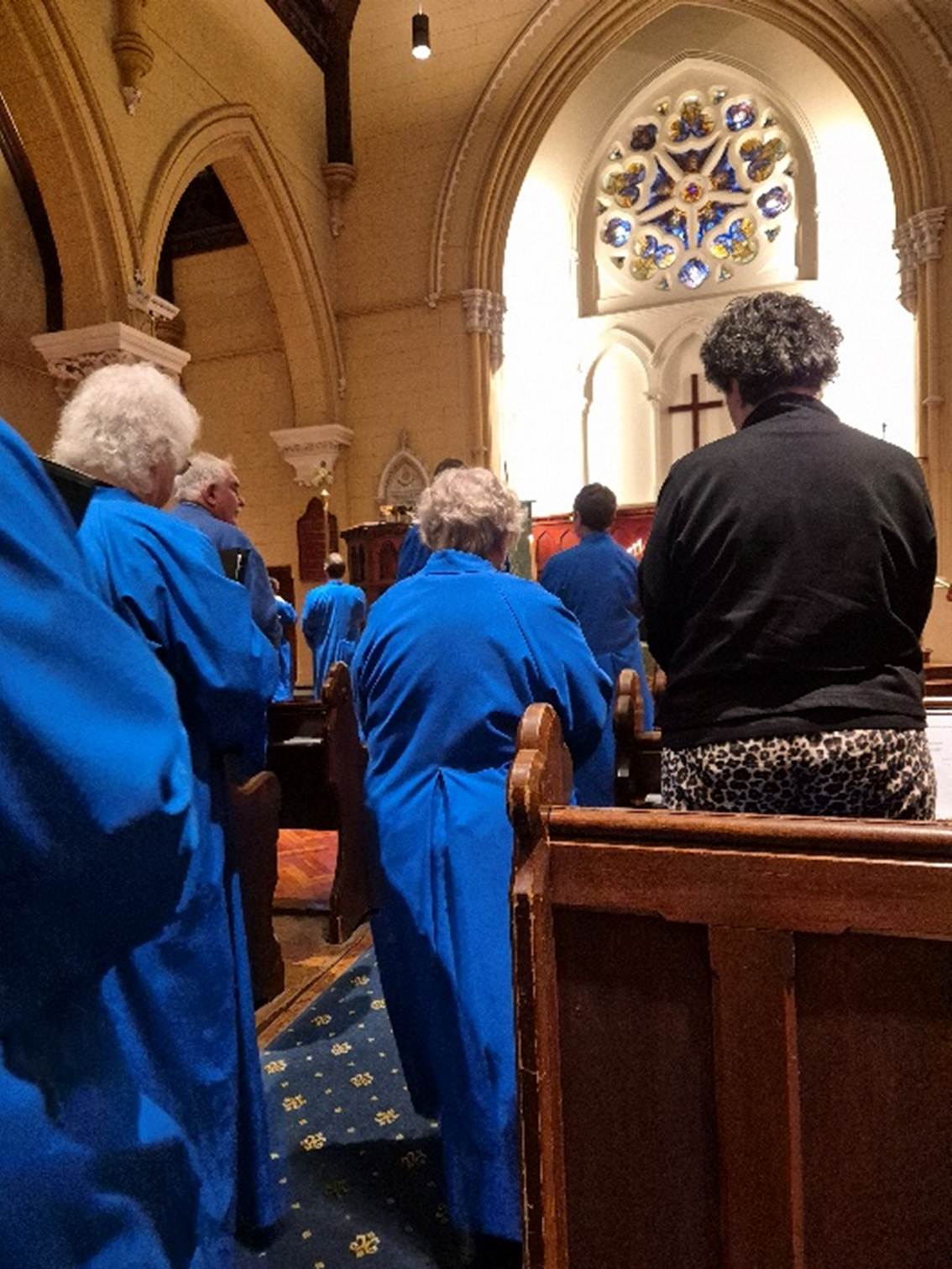 A group of people in blue robes in a church

AI-generated content may be incorrect.