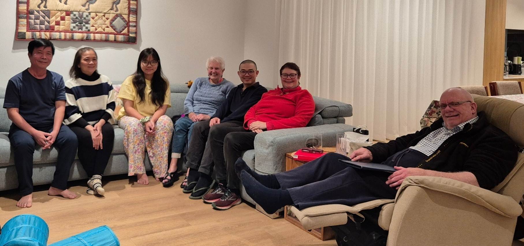 A group of people sitting on a couch

AI-generated content may be incorrect.